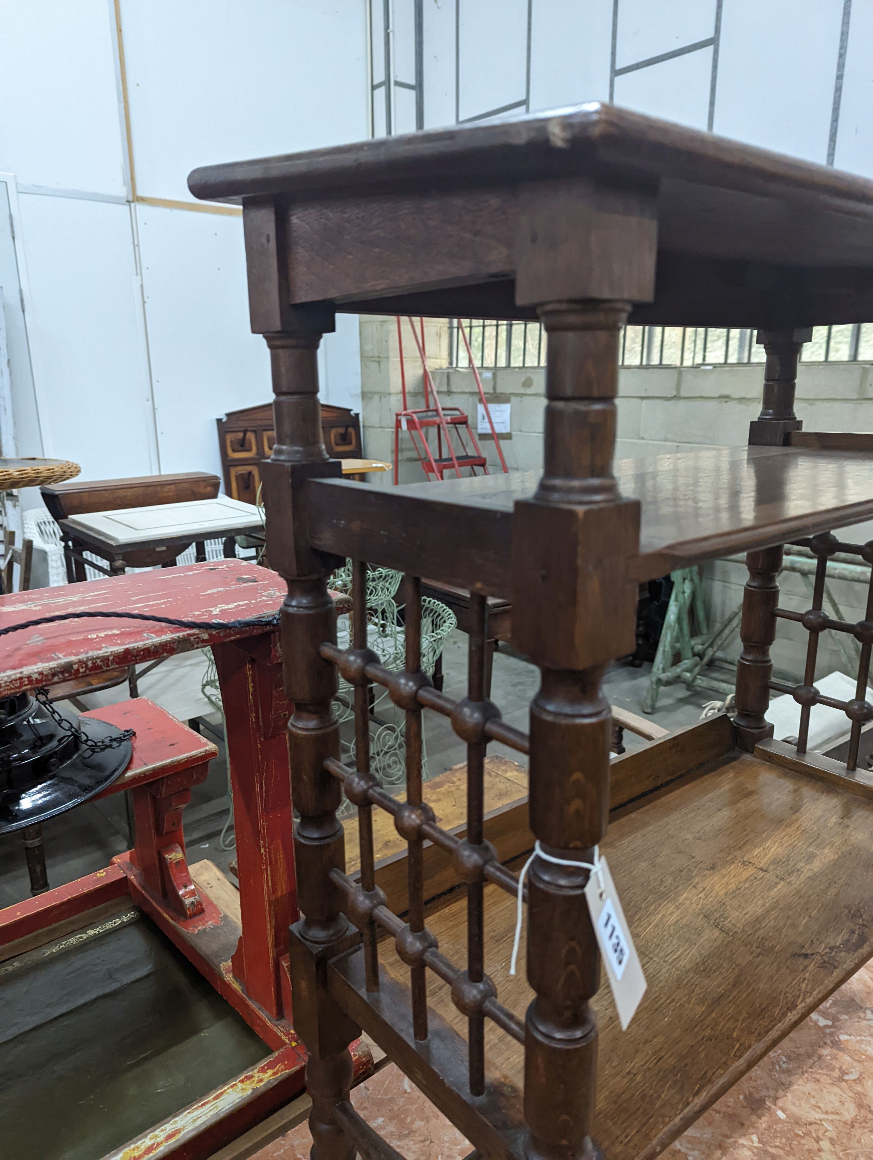 A late 19th century Continental oak three tier Liberty style table with slant top, width 70cm, depth 29cm, height 78cm